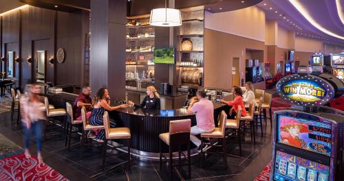 Un gruppo di persone seduti in un bar in un casinò di Southland Casino Hotel a West Memphis
