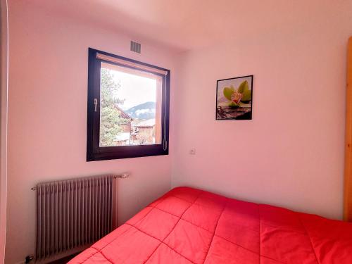 - une chambre avec un lit rouge et une fenêtre dans l'établissement Baraty, à Morzine