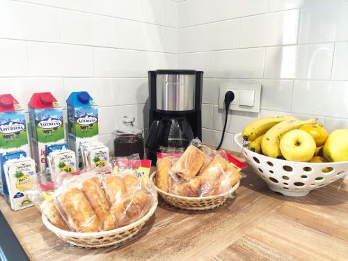three baskets of bread and bananas on a counter at Casa Rural La Madroña in Fuentelabrada de los Montes