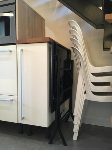 une cuisine avec un comptoir et une chaise blancs dans l'établissement Logement Climatisé Erdre Rivière, à La Chapelle-sur-Erdre