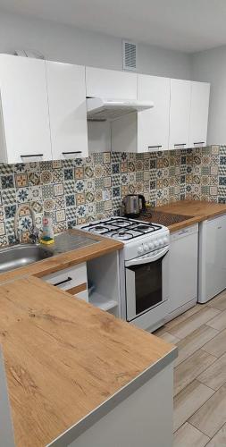 uma cozinha com electrodomésticos brancos e uma bancada de madeira em Apartament przy kładce em Przemyśl