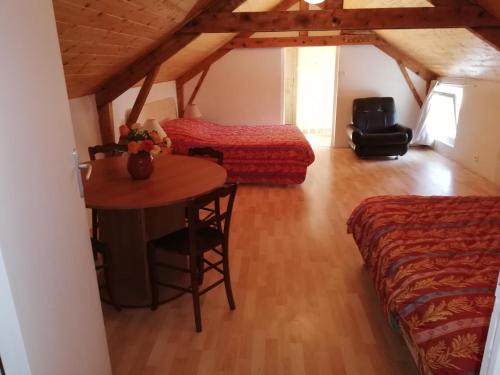 a room with a bed and a table in a room at Grand gite 14 personnes ,cour ,salle de jeux, proche du village , commerces in Murat