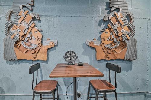 a table and two stools in front of a wall with a mural at Lake Luzerne Home with Fire Pit on Hudson River in Lake Luzerne
