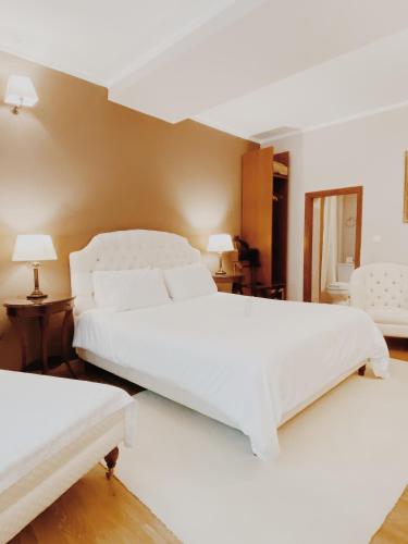 two white beds in a room with two lamps at Five Seasons in Nafplio