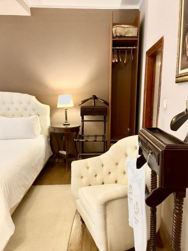 a bedroom with a white couch and a piano at Five Seasons in Nafplio