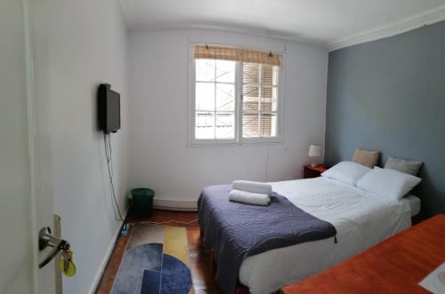 a bedroom with a bed and a window at HOSTAL SUZI in Santiago