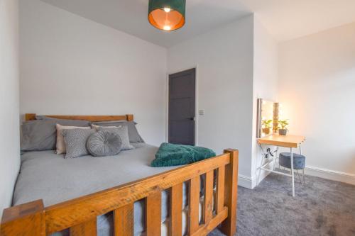ein Schlafzimmer mit einem großen Bett mit einem Holzrahmen in der Unterkunft Modernistic 4-bedroom home close to City Centre in Cardiff