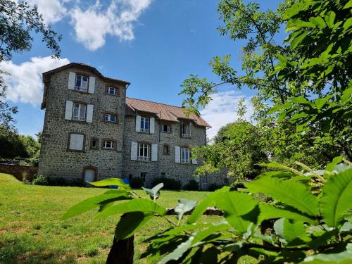 una vieja casa de piedra en un campo con árboles en Bon Chez Nous en Saint-Amand-Jartoudeix