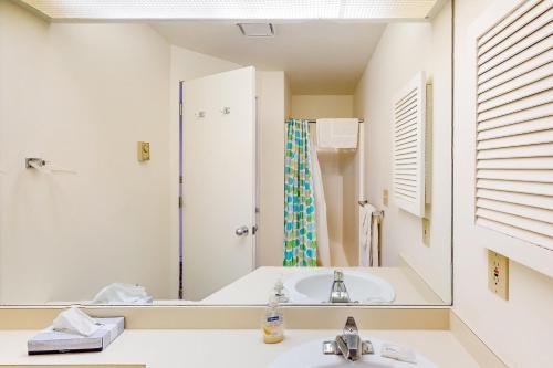 ein weißes Badezimmer mit einem Waschbecken und einem Spiegel in der Unterkunft Hawks Nest 58 in Glen Arbor