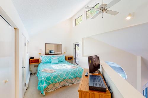 a bedroom with a bed and a desk with a laptop at Hawks Nest 58 in Glen Arbor