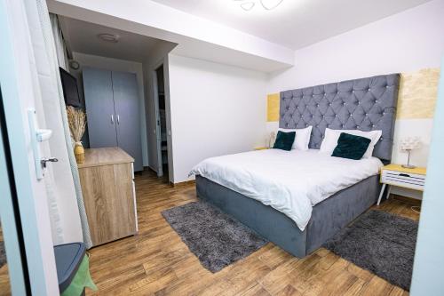 a bedroom with a large bed with a blue headboard at Pensiunea Ewo in Iaşi