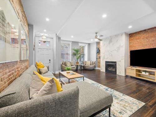 a living room with a couch and a tv at Stylish 4 Bedroom Loft Home, North Shore, City Skyline View Close to NHL, NFL in Pittsburgh