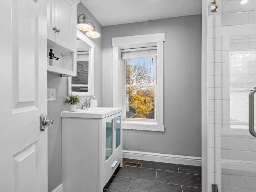 a bathroom with a sink and a window at Stylish 4 Bedroom Loft Home, North Shore, City Skyline View Close to NHL, NFL in Pittsburgh