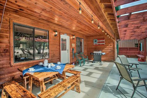 a porch with wooden walls and a table and chairs at Fire Pit, Fenced Yard Overgaard Cabin Near Hiking in Overgaard