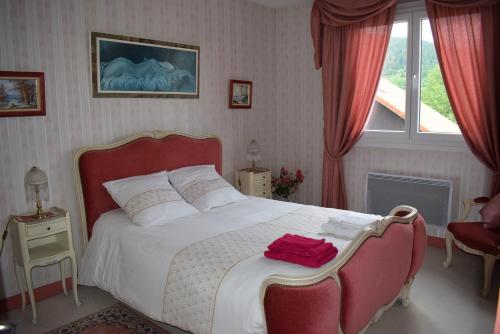 a bedroom with a large white bed with a red headboard at "Chez Vivi" logement 6 p classé 3 étoiles dans une belle maison au calme avec grande terrasse, balcon indépendant et wifi gratuite in Gérardmer