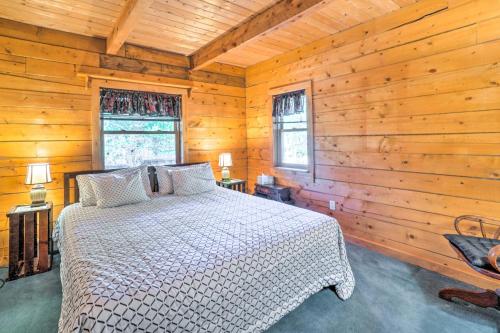 una camera con un letto in una baita di tronchi di Secluded Black Hawk Log Cabin with Fire Pit! a Black Hawk