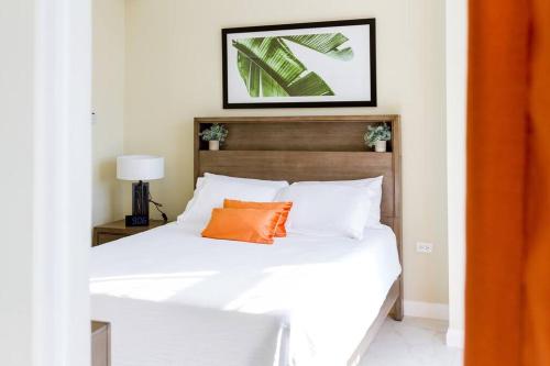 a bedroom with a bed with an orange pillow on it at Suite Retreat at The Lofts in Kingston