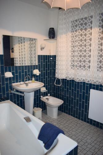 a bathroom with a sink and a tub and a toilet at "Chez Vivi" logement 6 p classé 3 étoiles dans une belle maison au calme avec grande terrasse, balcon indépendant et wifi gratuite in Gérardmer