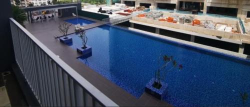 a large swimming pool with two potted plants on a building at Azin Ramli Studio in Seri Kembangan