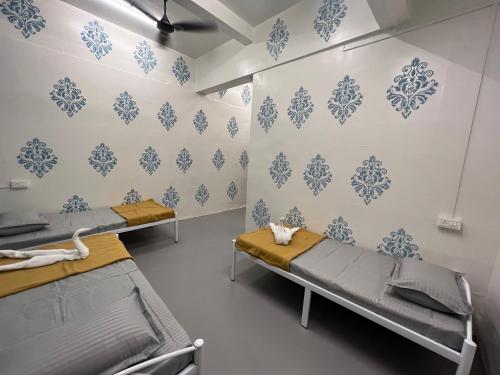 a hospital room with two beds with blue and white wallpaper at Backpackers hostel in Pune