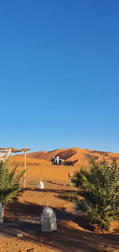 a group of people standing in the desert at Merzouga Bohemian Camp in Merzouga