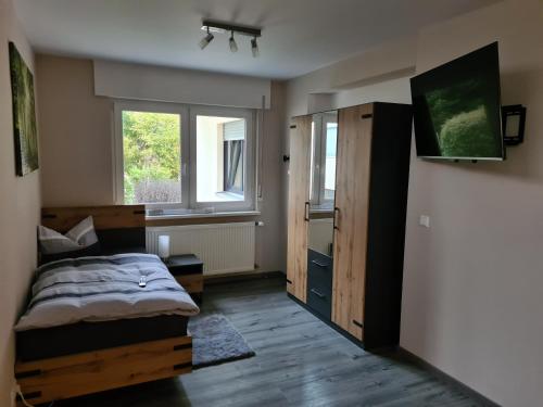 um quarto com uma cama e duas janelas em Pension Im Wiesengrund Steinau Marborn em Steinau an der Straße
