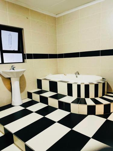 a bathroom with a black and white checkered floor at Airport Royal Guest House in Kempton Park