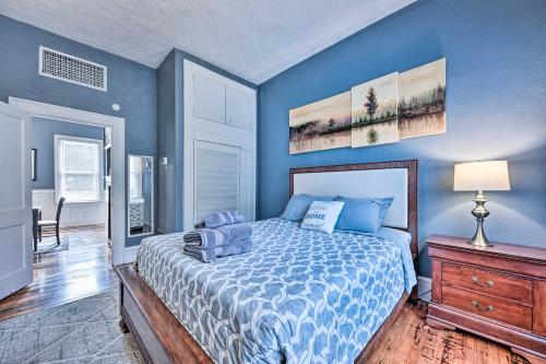 a bedroom with blue walls and a bed with a wooden dresser at Charming Jacksonville Home about 2 Mi to Downtown! in Jacksonville