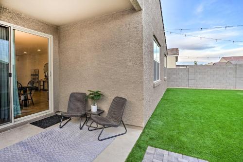 a patio with two chairs and a green lawn at New-Build Glendale Home with Hot Tub and Putting Green in Glendale