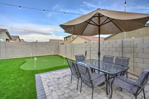 a patio with a table and chairs and an umbrella at New-Build Glendale Home with Hot Tub and Putting Green in Glendale