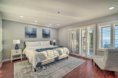 a bedroom with a bed and a chair and windows at Cliffside Pacifica Hideaway Unbeatable View! in Pacifica