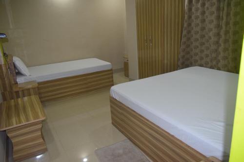 a small room with two beds in a room at Airport Lodge in Siliguri