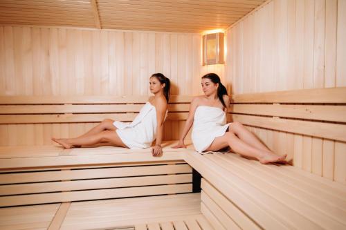 two women are sitting in a sauna at GasthauS & SPA in Bukovel