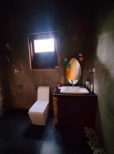 a bathroom with a toilet and a sink and a window at Sanuki Villa in Hikkaduwa