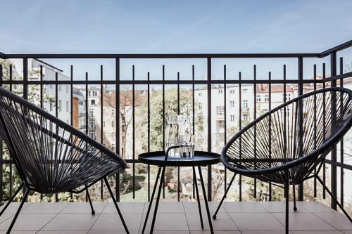 two chairs and a table on a balcony with a view at TurnKey I King George Square Studio in Prague
