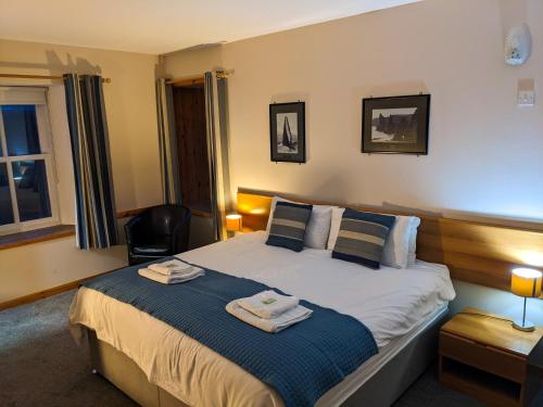 a bedroom with a bed with two towels on it at Ferry Inn in Stromness