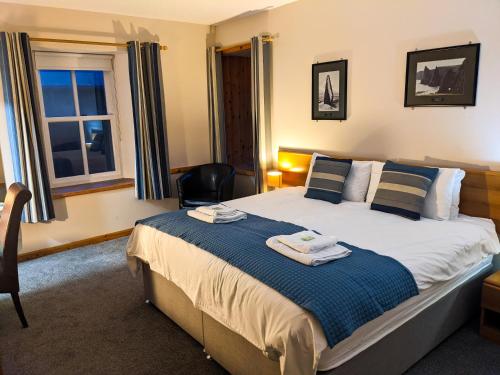 a bedroom with a bed with towels on it at Ferry Inn in Stromness