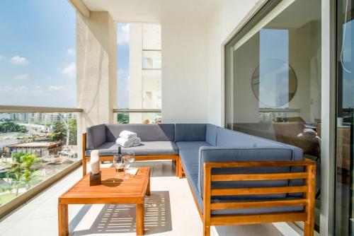 een woonkamer met een blauwe bank en een tafel bij Departamento en Paraiso Country Club - Amenidades de lujo in Cuernavaca