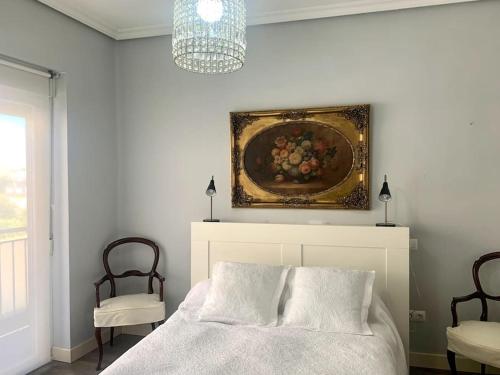 a bedroom with a bed and a painting on the wall at Tiger (wifi) in Ávila