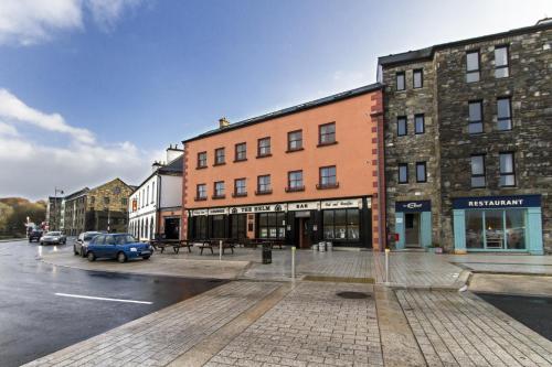 a street with buildings and a parking lot with a car at The Helm Apartments B&B in Westport