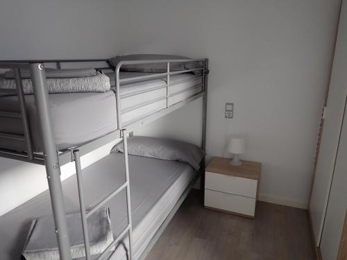 a bedroom with two bunk beds and a table at Apartaments L´AMFORA in Tossa de Mar