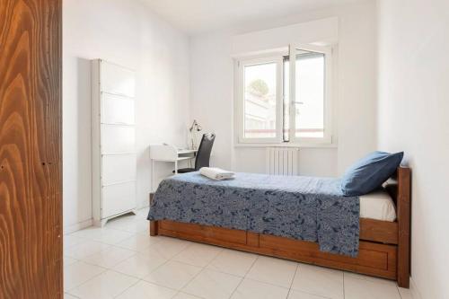 1 dormitorio con cama, escritorio y ventana en Attico incantevole - Forum Assago & Humanitas, en Rozzano