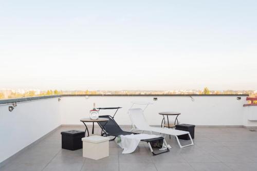 a room with chairs and tables and a large white wall at Attico incantevole - Forum Assago & Humanitas in Rozzano