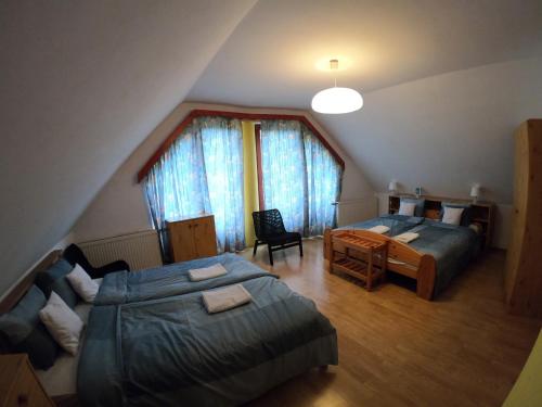 a attic bedroom with two beds and a desk at Tot&aacute;lis Harm&oacute;nia Villa in Miskolctapolca