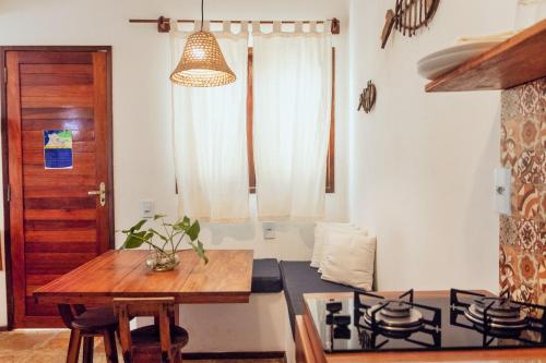 a kitchen with a wooden table and a stove at Manay Flats in Jericoacoara
