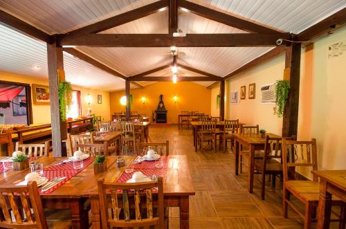um restaurante vazio com mesas e cadeiras de madeira em ECO RESORT FASCINAÇÃO em Miguel Pereira