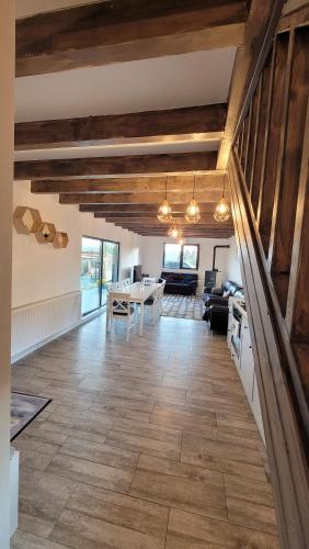 uma ampla sala de estar com tectos em madeira e uma mesa em Black Wood Cabin em Marisel