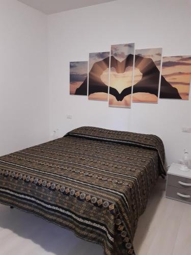 een bed in een kamer met drie foto's aan de muur bij alloggio le due querce in Acquapendente