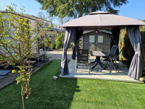 a gazebo with a table and chairs in a yard at Camping Vossenberg - op de Veluwe! in Epe