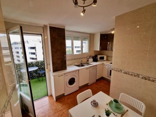 uma cozinha com uma mesa, um lavatório e uma máquina de lavar roupa em Apartamento Daniel Zaragoza em Zaragoza